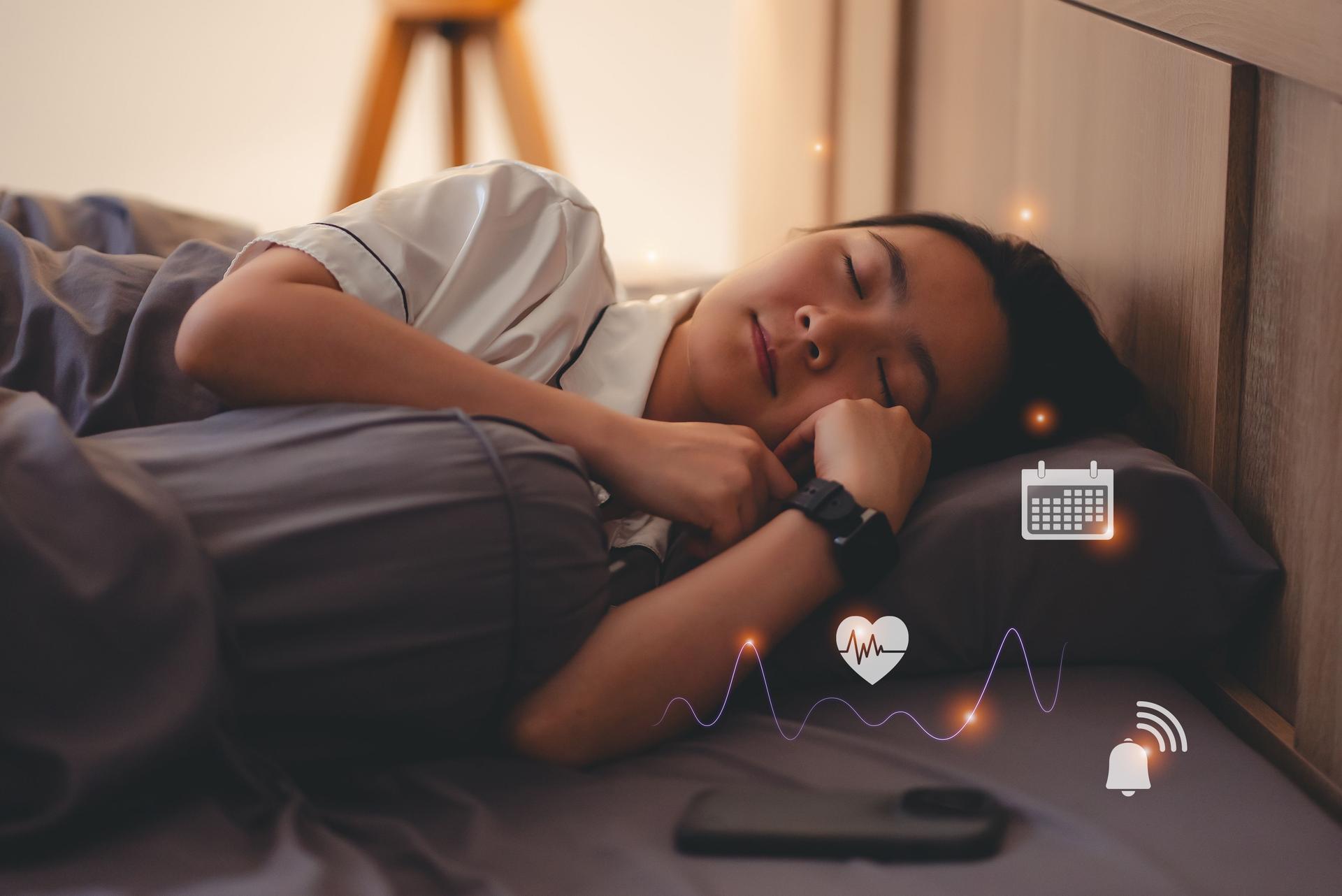 Asian woman wearing smartwatch for tracking sleep rate showing icon by hologram virtual.